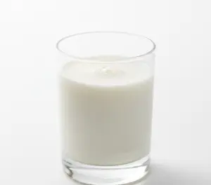 Макро фото стакана свежего белого молока на столе